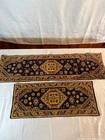 Both rugs laid flat showing size difference and full pattern