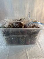 Two translucent storage bins, one containing jarred beads, the other sealed bags of bead strands