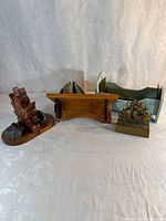Group shot showing maple leaf bookends, stone bookends, brown wooden mini shelf, green bookend shelf and brass bookends