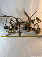 Group shot of all 12 brass animals and birds with measuring tape