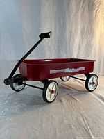 Side view of red Venture Express wagon showing graphics, handle and wheels