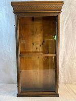 Front view of antique oak cabinet with glass door