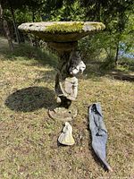 Full view of bird bath with two ornaments on ground