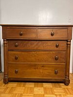 Front view showing all five drawers, turned columns and knobs