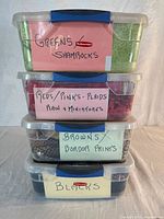 Stack of four labelled clear plastic boxes