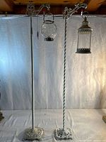 Both metal floor lamp stands with hanging globe and lantern