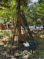 Bundle of shepherd hooks, arched fence panels, bin of green wire fencing