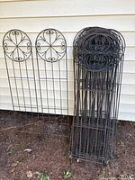 Stack and grouping of black metal trellises showing design and quantity
