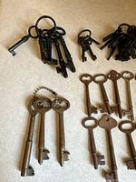 Multiple bundles of iron and brass skeleton keys, some on rings, showing variety of shapes and sizes