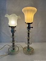 Two glass base lamps with frosted shades side by side