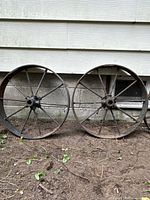 Both wheels leaning against foundation wall displaying full rims and spoke pattern