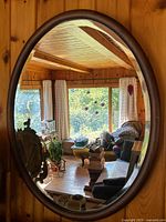 Front view of oval mirror reflecting room interior