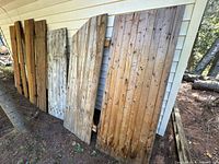 Six pine panels/doors leaning against exterior wall