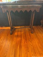 Front view of wooden console table showing scalloped edge top and barley-twist legs