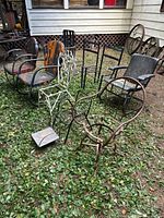 Group shot of assorted metal chairs arranged outdoors showing variety