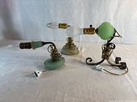 All three pale green glass wall sconce lamps with cords visible