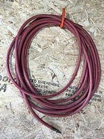 Coiled red rubber air hose on plywood surface