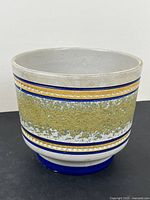 Front view showing gold band and blue stripes