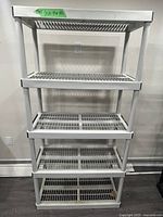 Full view of white plastic shelving unit with four shelves