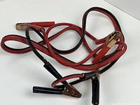 Coiled red and black jumper cables showing all four copper-plated clamps