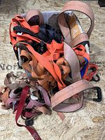 Box filled with assorted coloured tie-down straps with hooks