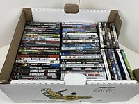 Open box showing two rows of DVD cases in spine view plus additional cases on side; illustrates quantity and condition