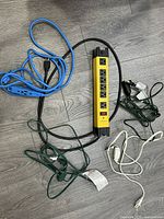 Overview of power bar and multiple extension cords on floor