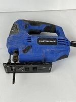 Blue Mastercraft corded jigsaw, side view showing body, shoe and blade