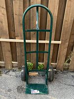 Front view of green metal hand truck with wheels and toe plate visible