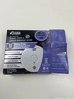 Retail box front showing Kidde talking smoke & CO alarm details and damaged packaging