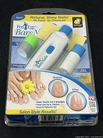 Front of sealed PedEgg Bare Nails kit showing device and rollers