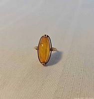 Front view of rose gold ring with oval Baltic amber cabochon