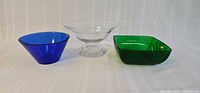 Three glass bowls: blue, clear pedestal, green