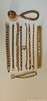 All ten gold-tone bracelets laid flat