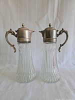 Front view of both glass decanters with ornate silver-plate tops