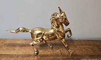 Full left-side view of brass horse figurine