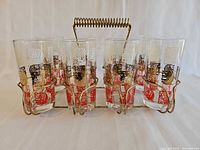 front view of eight patterned glasses in gold-tone carrier