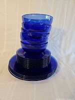 Stacked view of cobalt blue bowls atop plates showing quantity and color