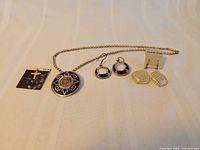 Full group shot showing brooch-pendant, chain, earrings, totem charm