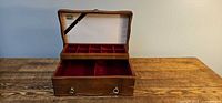 Box open showing red velvet-lined tray with compartments and lower section