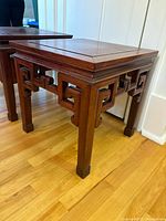 Two matching rosewood side tables angled view