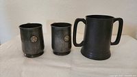 Three pewter tankards front view