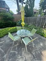 overview of patio set showing table, 4 chairs, umbrella