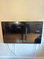 Front view of wall-mounted Vizio TV, screen off