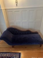Full view of fainting couch against paneled wall