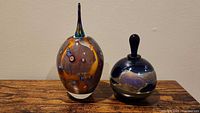 Both art glass perfume bottles side by side on table