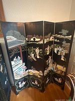 Full view of 4-panel black lacquer Asian privacy screen unfolded