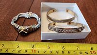 Overview of three bracelets with measuring tape for scale