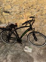 Full left-side view of Goccia Holiday M electric bicycle showing frame, wheels, battery and placard