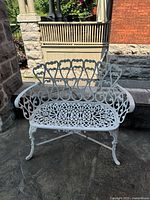Full view of ornate white cast iron garden bench